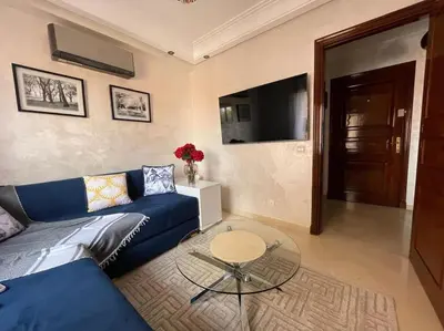 a living room with a blue couch and a table at Stylish & Comfy Gem 5 Star Location Balcony in Marrakech