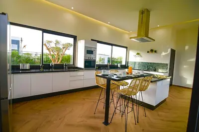 a kitchen with a table and some chairs in it at Villa Alanaé piscine chauffée in Douar Bellouk