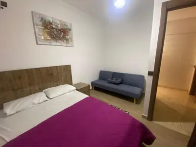 a bedroom with a bed and a blue couch at نور 5 كليز in Marrakech