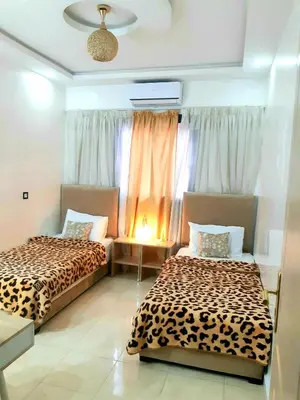 two beds sitting in a room with curtains at COZY Appartement in Marrakech