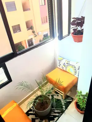 a small balcony with a bench and a plant at COZY Appartement in Marrakech