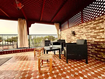 a living room with a couch and a table and chairs at Triplex spacieux et familial avec une vue panoramique in Marrakech