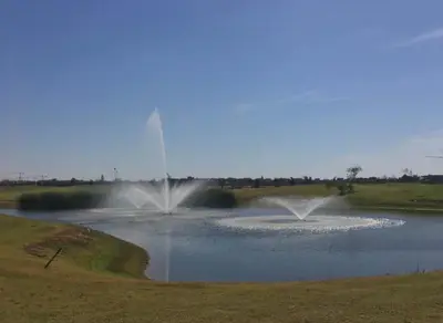 a pond with a fountain in the middle of a field at Appartement exceptionnel avec golf in Marrakech