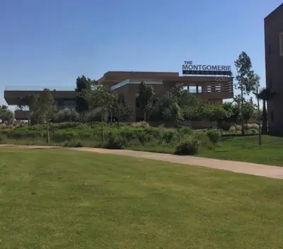 a building with a grass field in front of it at Appartement exceptionnel avec golf in Marrakech