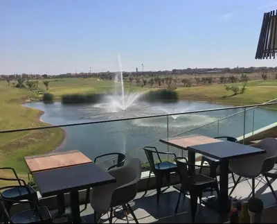 a balcony with tables and chairs and a fountain at Appartement exceptionnel avec golf in Marrakech