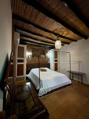 a bedroom with a white bed and a table at 2 Habitaciones en magnifico riad in Marrakech