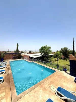 a large swimming pool with lounge chairs next to it at 2 Habitaciones en magnifico riad in Marrakech