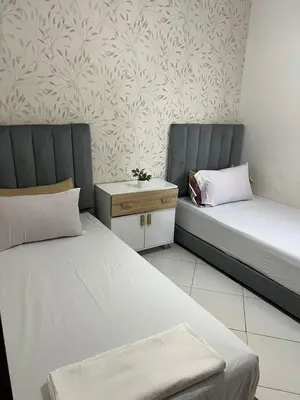 a room with two beds and a nightstand between them at TerHouse in Marrakech