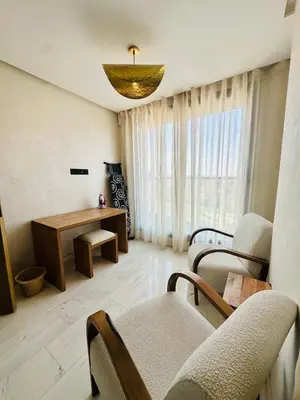 a living room with chairs and a table and a chandelier at Sompteux Appartement 1 chambre Piscine à Marrakech in Marrakech