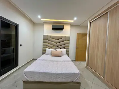 a bedroom with a bed and a tv on the wall at Immokesch1 in Marrakech