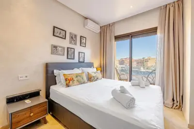 a bedroom with a large bed with a large window at MARJANA Luxe appartement in Marrakech
