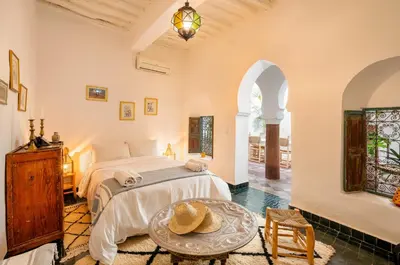 a bedroom with a bed and a table at Riad Banafsaj - Exclusif - 20mn de Jamaa Al Fnaa in Marrakech
