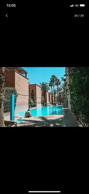 a picture of a swimming pool with a person sitting next to it at Tourist Riad in Marrakech