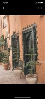 a building with a door and potted plants on a street at Tourist Riad in Marrakech