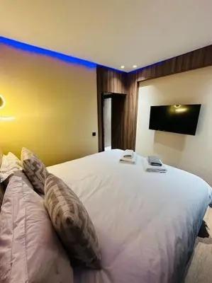 a bedroom with a large white bed with two phones on it at Sublime Appartement 1 chambre WIFI à Marrakech in Marrakech