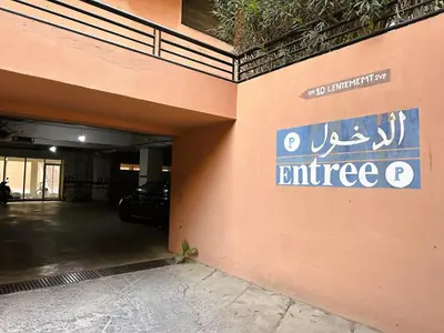 a parking garage with a sign on the side of a building at Calme et cozy avec piscine in Marrakech