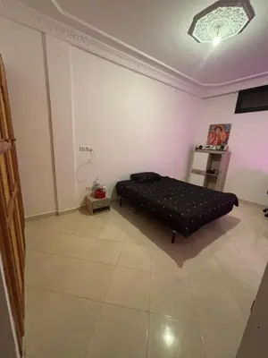 a bedroom with a black bed in the corner of a room at Petite villa cosy et agréable avec jacuzzi privé in Marrakech