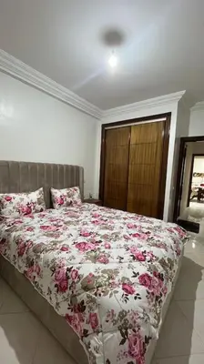 a bedroom with a bed with pink flowers on it at Appartement de luxe en plein centre à Marrakech in Marrakech