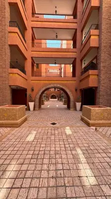 an empty hallway in a building with a brick floor at Cozy apartment in city center in Marrakech