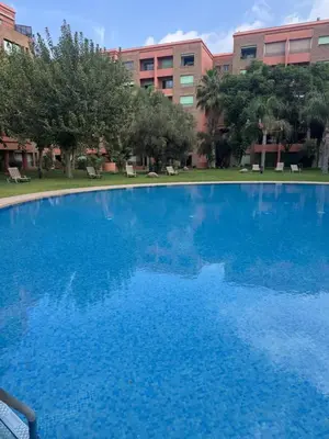 a large blue swimming pool in front of a building at Cozy apartment in city center in Marrakech