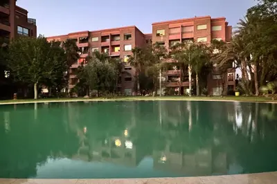 a large pool of water in front of a building at Cozy apartment in city center in Marrakech