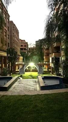 a park with a fountain in the middle of a city at Cozy apartment in city center in Marrakech
