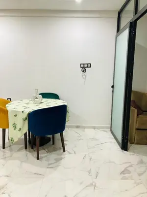 a white room with a table with a blue chair at Magnifique appartement à Marrakech in Marrakech