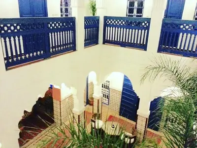 a lobby with blue benches and a model of a city at Riad Dar Colline in Marrakech