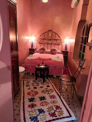 a bedroom with a bed and a rug at Riad Dar Colline in Marrakech