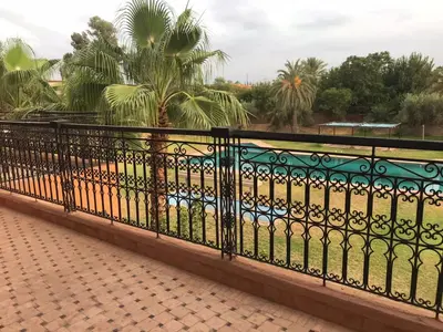 a black fence with a view of a beach at Lot tichka villa n6 in Marrakech