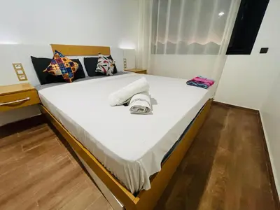 a bed with white sheets and pillows on it at Super appartement in Marrakech