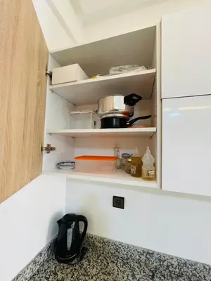 a kitchen cabinet with some food items in it at Super appartement in Marrakech