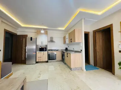 a large kitchen with wooden cabinets and stainless steel appliances at Super appartement in Marrakech
