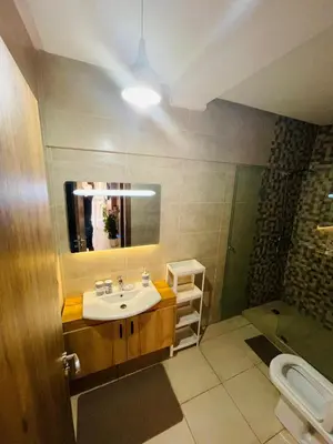 a bathroom with a sink and a mirror and a toilet at Super appartement in Marrakech
