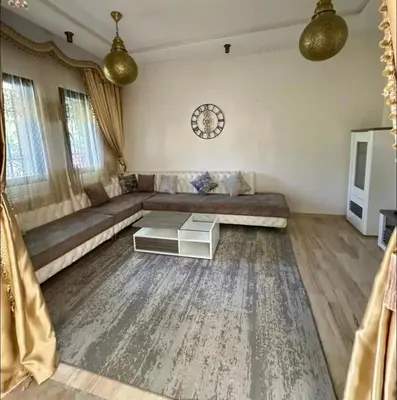 a living room with a couch and a table at Charmant villa au cœur de la palmeraie in Douar Caïd Layadi