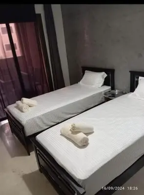 two beds in a room with towels on them at Chic et Cosy deux chambres avec Piscine in Marrakech
