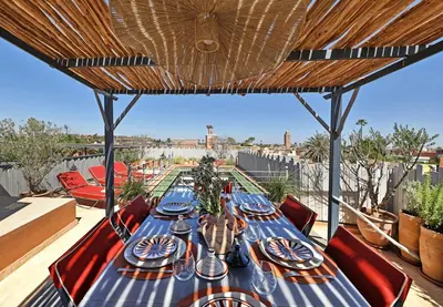 a table with plates and dishes on top of a roof at Riad dar Tayri in Marrakech