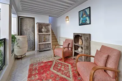 a living room with two chairs and a rug at Riad dar Tayri in Marrakech