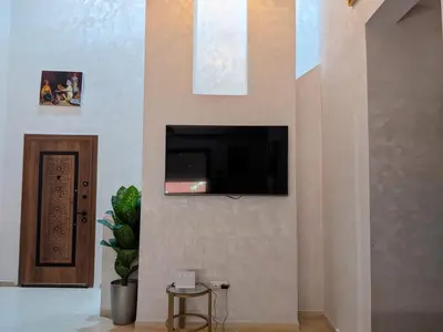 a living room with a tv on a wall at Janat House in Marrakech