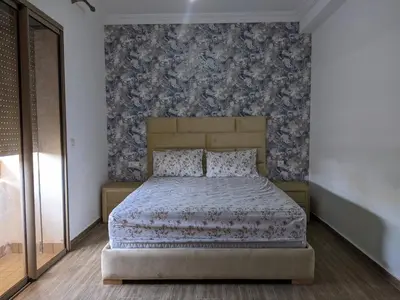 a bedroom with a bed with a blue and gray wallpaper at Janat House in Marrakech