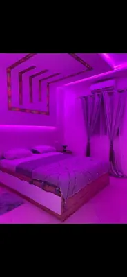 a bedroom with a bed with purple lighting at Marrakech Les portes de gueliz 2 immeuble 4 appartement 29 in Marrakech