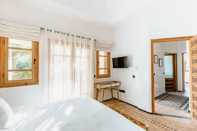 a white bedroom with a bed and a desk at La Villa d'Oz pour 12 personnes Golf Amelkis in Marrakech
