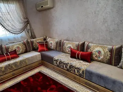 a living room with a couch with red pillows at Appartement avec piscine Guéliz in Marrakech