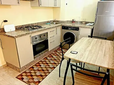 a kitchen with a stove and a table with a tableablish at Séjour spacieux à Marrakech in Marrakech