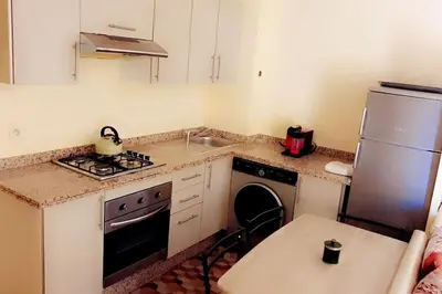 a kitchen with a sink and a stove and a refrigerator at Séjour spacieux à Marrakech in Marrakech