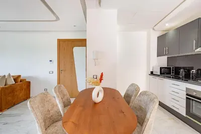 a dining room with a wooden table and chairs at New! Appt Riad Garden, piscine & wifi & parking in Marrakech