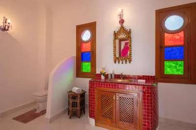 a bathroom with a sink and a toilet with stained glass windows at Villa 5 suits with pool and montains view in Sraghna