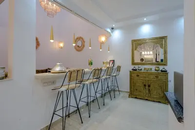 a kitchen with a bar with stools and a counter at Dar Mawati Traditional Private Guesthouse Marrakech in Marrakech
