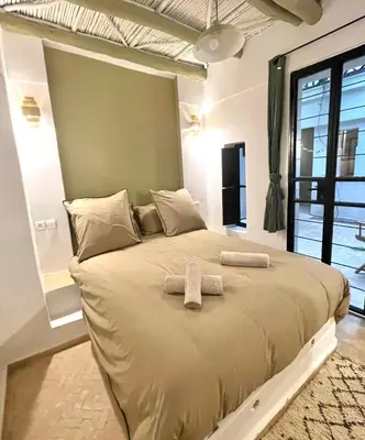 a bedroom with a large bed with two towels on it at Riad Dardeco privé centre Medina Marrakech in Marrakech