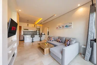 a living room with a couch and a table at Relax Front of Pool - Golf- Fiber Optic in Marrakech